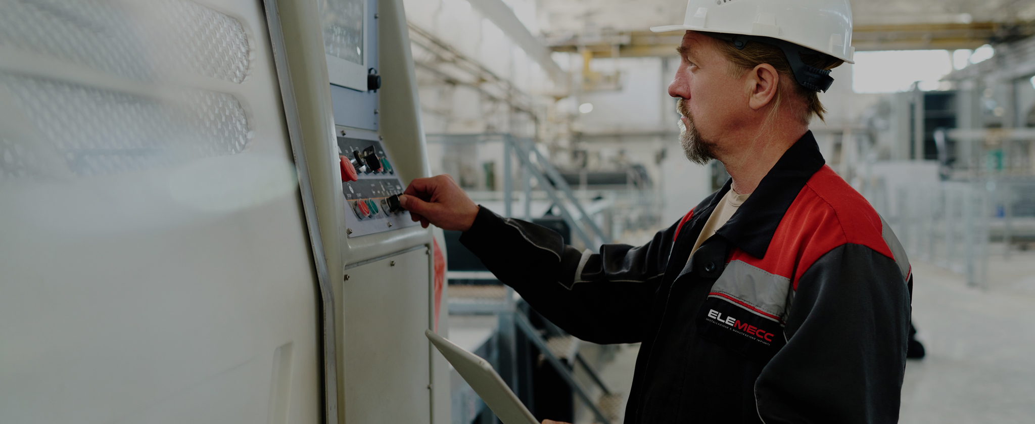 tecnico specializzato durante la manutenzione di macchinari industriali tramite pannello di controllo