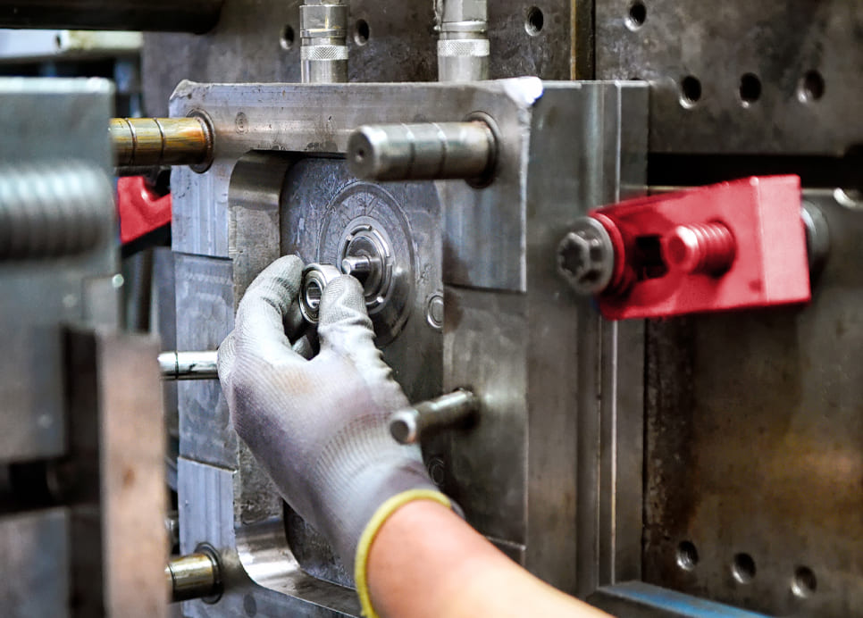 tecnico durante montaggio di componenti meccanici su macchinario industriale